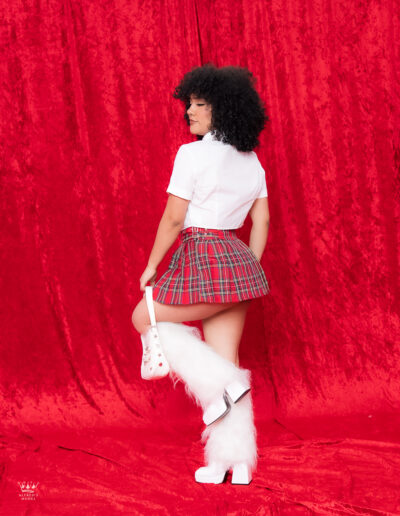 Sesión editorial de modelo femenina en estudio con vestuario colegial moderno