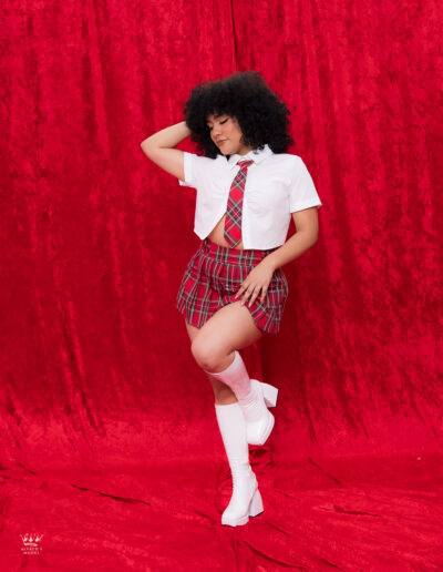 Modelo posando en sesión creativa con fondo rojo en estudio fotográfico profesional