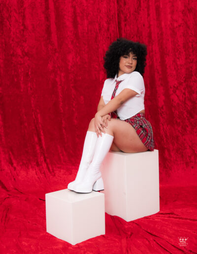 Retrato editorial de modelo en estudio con falda roja de cuadros y botas blancas en Alfred’s Model